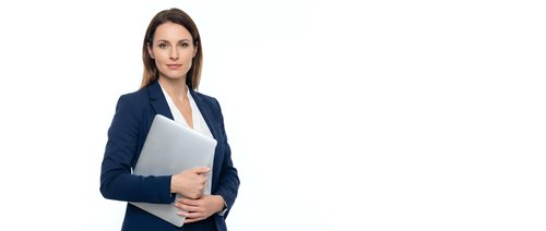 Professional woman with dark hair and fair complexion wearing navy blazer and white shirt, holding laptop computer against white background for corporate business portraits.