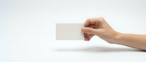 Hand holding blank white business card mockup on clean background for branding and corporate identity design projects.
