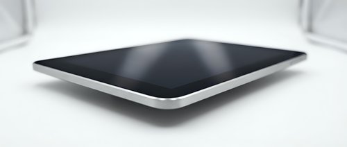 Modern black tablet computer with silver frame lying flat on white surface, sleek design for technology and digital device concepts.