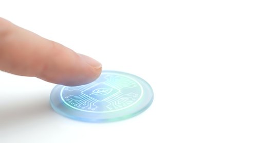 Finger touching holographic security element with intricate patterns on white background for authentication and verification technology concepts.