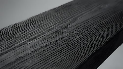 Dark weathered wood plank with natural grain texture and rustic surface details for construction and carpentry projects.