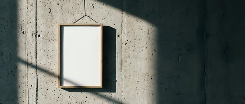 Empty wooden frame hanging on concrete wall with dramatic shadow patterns from window light creating minimalist interior design mockup space.