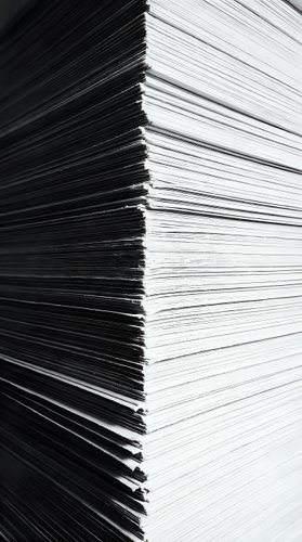 Stack of white paper sheets with black edges showing thickness and layers for office and business documentation needs.