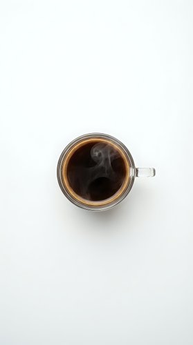 Glass mug of hot black coffee with steam rising on white background, top view flat lay for morning beverage and cafe menu design.