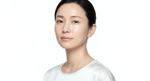 Young Asian woman with natural makeup and clean skincare routine wearing white shirt on isolated background for beauty and wellness concepts.