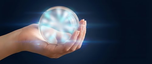 Hands holding glowing crystal ball with radiant light beams on dark background for fortune telling, magic, spirituality and mystical energy concepts.