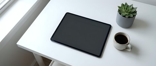Modern workspace with black tablet, coffee cup and succulent plant on clean white desk for business productivity and digital lifestyle.