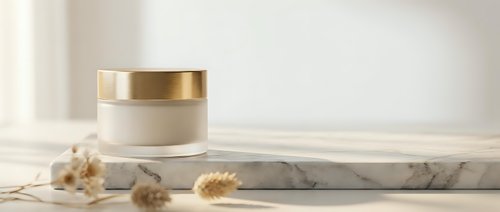 Luxury skincare cream jar with golden cap on marble surface with dried flowers for premium beauty and cosmetic product packaging design.