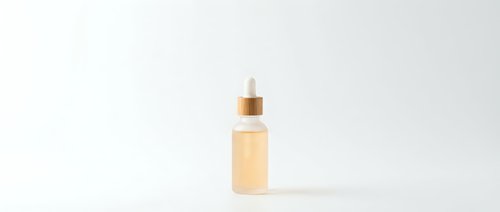 Cosmetic serum bottle with dropper on white background, skincare product packaging for beauty and wellness branding, isolated for design use.