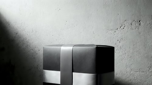 Elegant gift box wrapped with ribbon on concrete background, monochrome luxury present for holiday, birthday or corporate celebration.