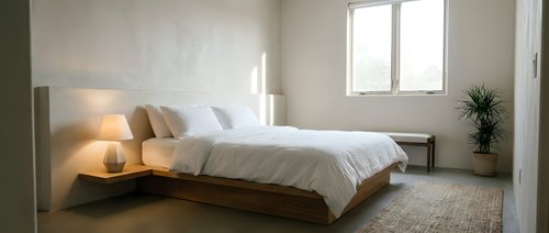 Modern minimalist bedroom with floating wooden bed frame, white bedding, and natural lighting creating serene sleeping space for interior design.