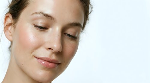 Young Caucasian woman with natural makeup and glowing skin, eyes closed in peaceful expression, skincare and beauty concept for wellness advertising.
