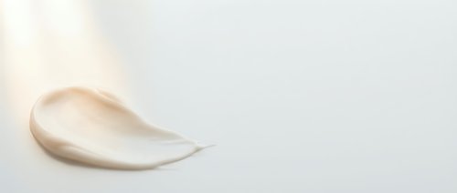 Creamy cosmetic texture smear on white background, skincare product sample for beauty and wellness applications.