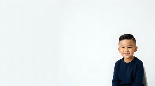 Young boy, approximately 6-8 years old, East Asian ethnicity, wearing dark navy blue long-sleeve shirt, isolated on white background, suitable for educational materials, family websites, and children's product design.