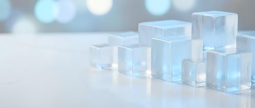 Clear glass cubes arranged in rows on white surface with soft bokeh background for modern minimalist design and contemporary decor concepts.