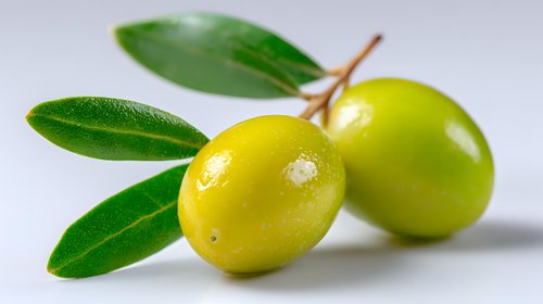 Fresh green olives with leaves on light background, close up view showing natural texture and shine. For food, cooking, and healthy lifestyle concepts.