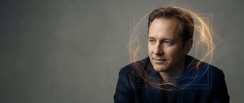 Middle-aged Caucasian male professional wearing dark blue casual shirt against neutral gray background, suitable for corporate portraits, business websites, and professional headshots.