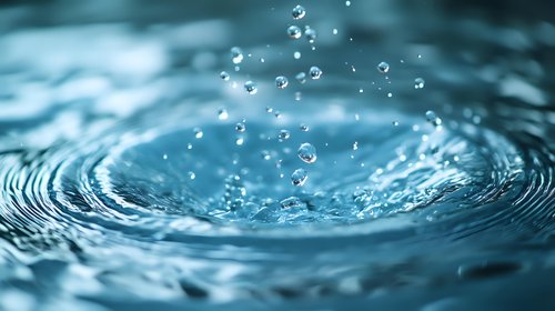 Mesmerizing macro shot of water droplets creating concentric ripples on turquoise water surface with floating bubbles and dynamic splash effect. Perfect for wellness concepts.