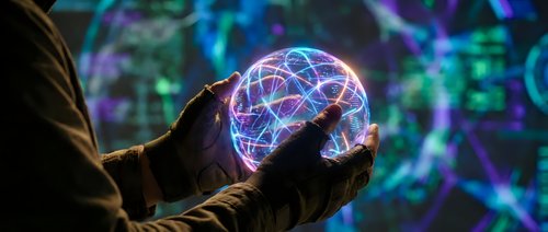 Young adult male with medium skin tone wearing dark gloves holding glowing neon sphere with digital network lines, representing technology, innovation, and data connectivity concepts.