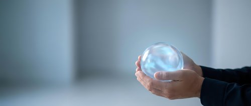 Hands of a businessman holding a glowing crystal ball, symbolizing future vision, prediction, and innovation in business strategy.