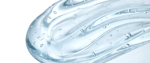 Clear gel or serum with water droplets flowing across textured surface, isolated on white background for skincare, cosmetics, and beauty product packaging design.