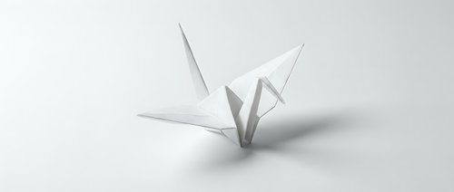 White origami paper crane on clean background symbolizing peace, hope and Japanese art tradition for meditation and mindfulness concepts.