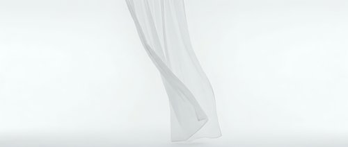 Flowing white fabric curtain with elegant drape movement on light background for interior design and home decor projects.