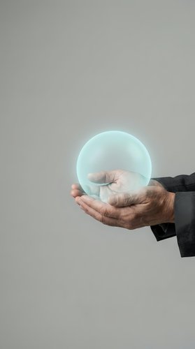 Mature male hand in dark business suit holding glowing translucent sphere against neutral background. Concept for innovation, technology, future vision, and business solutions.