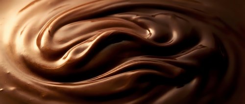 Smooth chocolate liquid swirls in rich brown tones, creating an abstract flowing pattern suitable for food, beverage, and confectionery design projects.