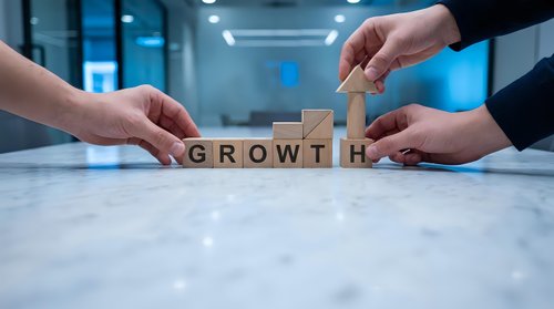 Business team building GROWTH word with wooden blocks on office table representing teamwork and company development strategy.
