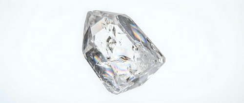 Crystal clear diamond gemstone with brilliant faceted cuts reflecting light on white background isolated for jewelry design and luxury concepts.