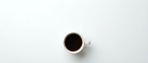 Black coffee in white ceramic mug on clean white background, minimalist flat lay composition for morning beverage concepts and cafe branding materials.