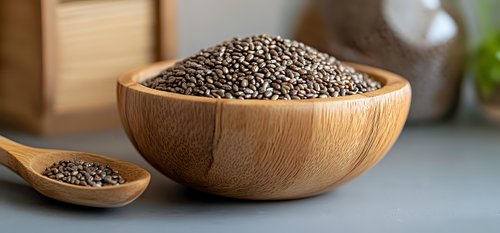 Raw chia seeds in wooden bowl and spoon on gray background, healthy superfood rich in omega-3 fatty acids and fiber, natural organic ingredient.