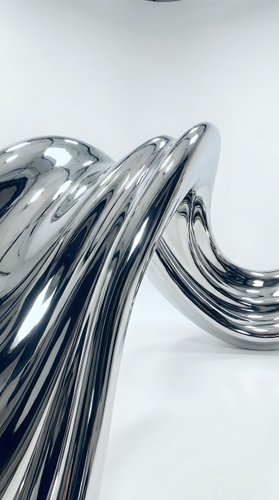Abstract chrome liquid metal waves flowing in smooth curves with reflective surface creating modern futuristic design element for contemporary projects.
