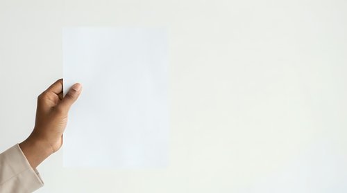 Male hand with medium-dark skin tone holding blank white card or paper against neutral background, suitable for mockups, advertising, and promotional designs.