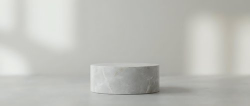 Minimalist concrete cylinder podium on neutral surface with soft natural lighting and shadows for product display and presentation purposes.