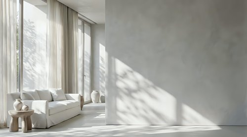 Modern minimalist living room interior with white sofa, natural sunlight streaming through large windows creating geometric shadows on concrete wall.