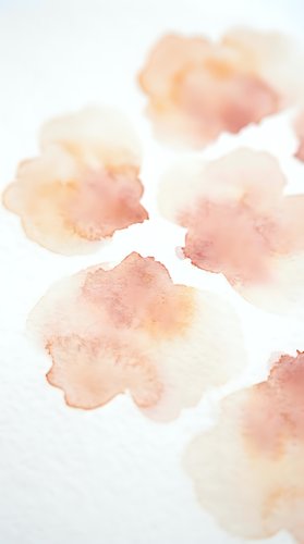 Soft watercolor stains in warm peach and coral tones on white paper texture for artistic backgrounds and creative projects.