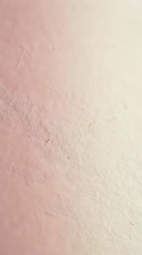 Soft pink gradient textured surface with natural grain pattern fading to cream, organic material background for cosmetic and wellness design projects.