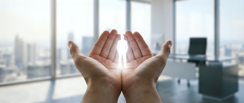 Businessman hands cupped together holding glowing light in modern office with city skyline view representing hope, innovation and business success.