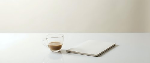 Espresso cup with saucer and notebook on white surface for coffee break, workspace, and beverage concepts.