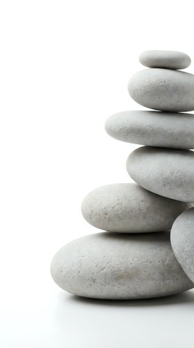 Stacked smooth gray stones isolated on white background, symbolizing balance, wellness, and zen meditation for spa and mindfulness design projects.