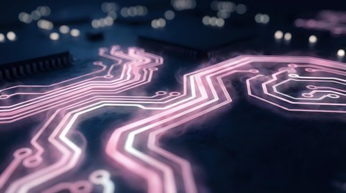 Futuristic neon pink circuit board pathways with glowing electronic traces on dark surface creating high-tech digital technology background for modern designs.