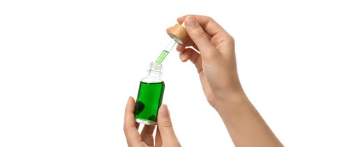 Hands applying green serum with dropper for skincare routine on white background isolated for cosmetic and beauty product design.